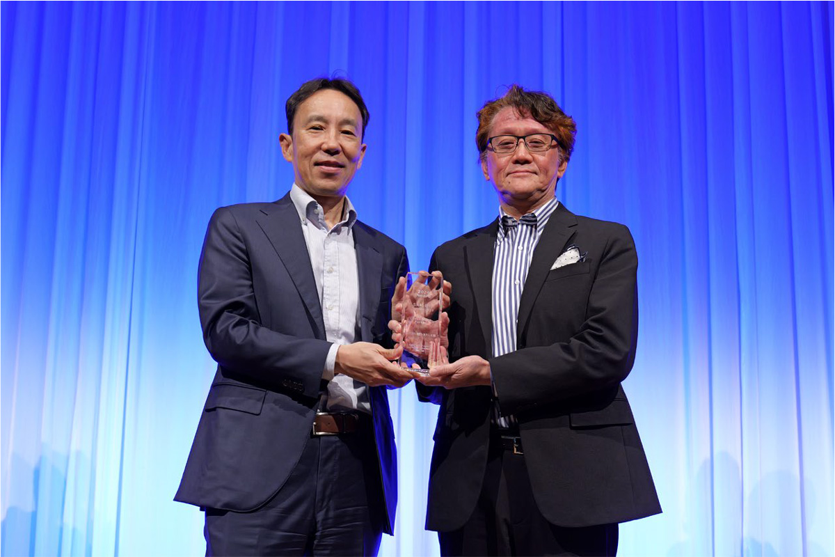 表彰式の写真（セゾンテクノロジー 葉山 誠 代表取締役 社長執行役員（左）と日立システムズ ビジネス＆クラウドサービス事業グループ アライアンス・サービス事業部 副事業部長 大野 哲史（右））